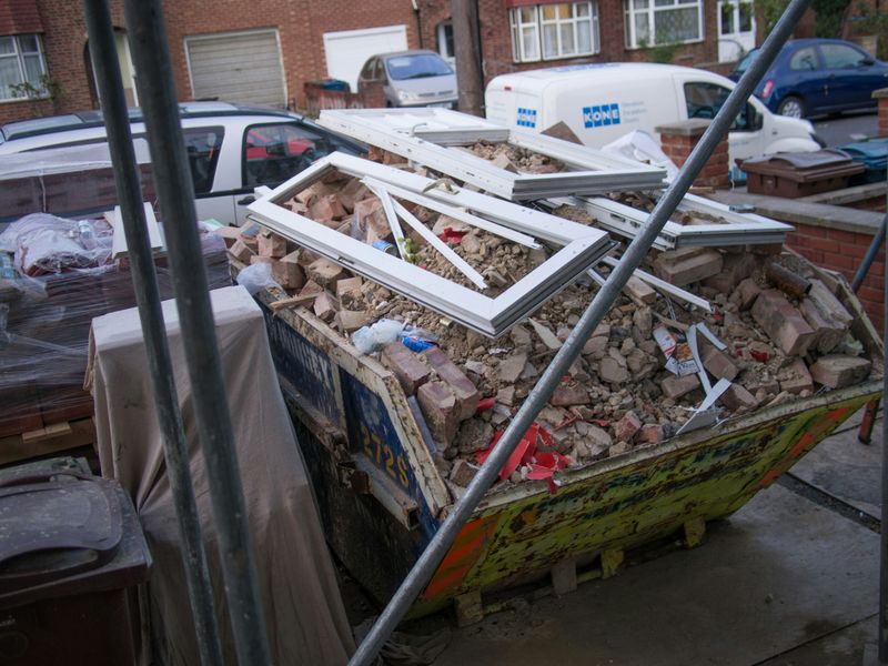A builder's skip filled with construction rubble and timber